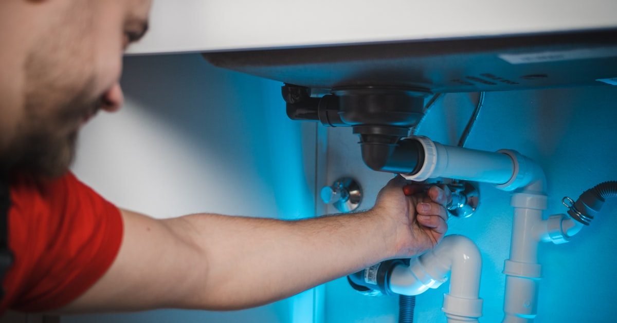 Licensed plumber repairing a sink drain in a Las Vegas home